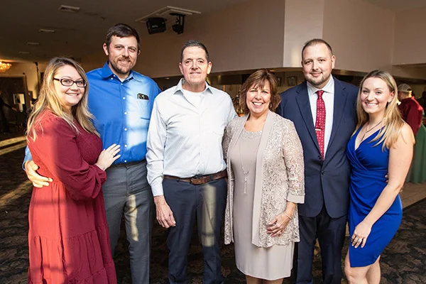 Family of six posing together at an indoor event