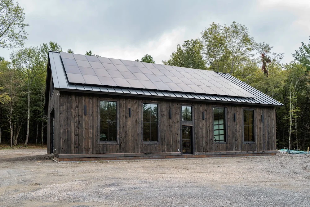Modern barn-style building clad in dark vertical wood siding