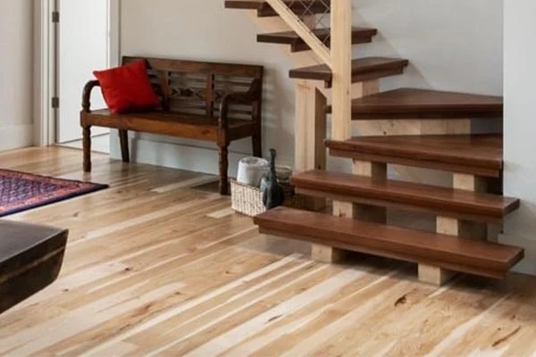 Pale hickory boards in an entry with bench and open stair